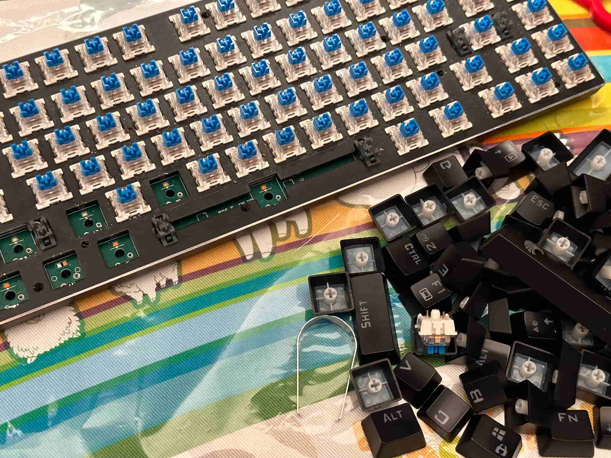 My E-Yooso Z-88 mechanical keyboard with its keycaps taken off, showing blue switches. Some switches popped out easily, but others were stubborn and hard to remove